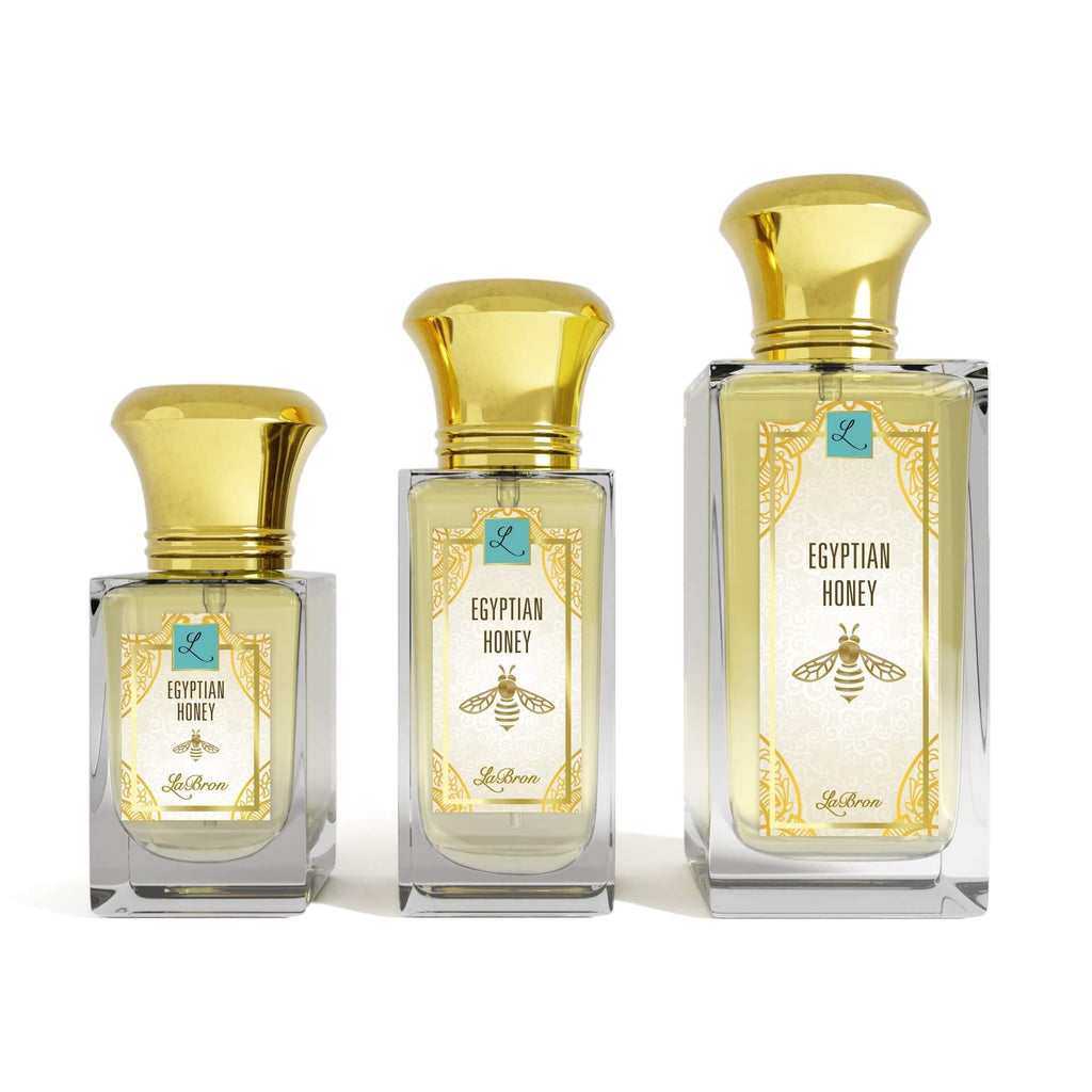 Three sizes of the Egyptian Honey fragrances laid out in a line with a white background. The label shows a a gold egyptian-style bee with a white background with "Labron" on their label.