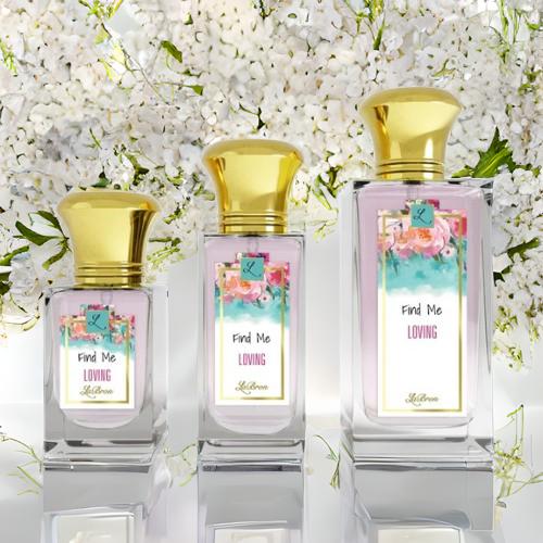 Find me "Loving" products showcased in a line. This products shows a floral like background on their label and gold cap. The background is surrounded by white florals and a glass bottom reflecting the products and surroundings.