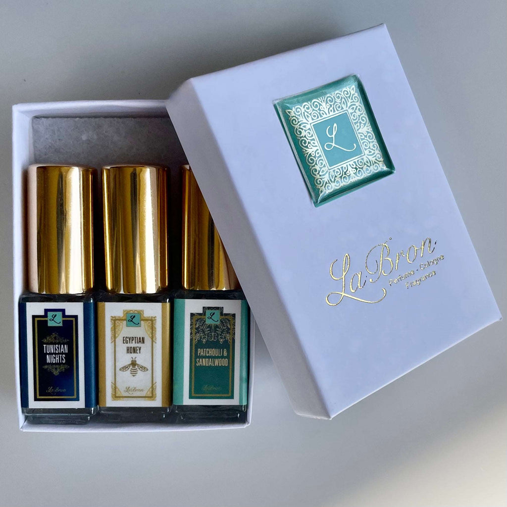 LaBron Perfume Sample Set; with your choice of Three or Six 5 ml Sprays. The box that comes with the products are in a white box with gold lettering for the label. The background is a white background that brings it all together.