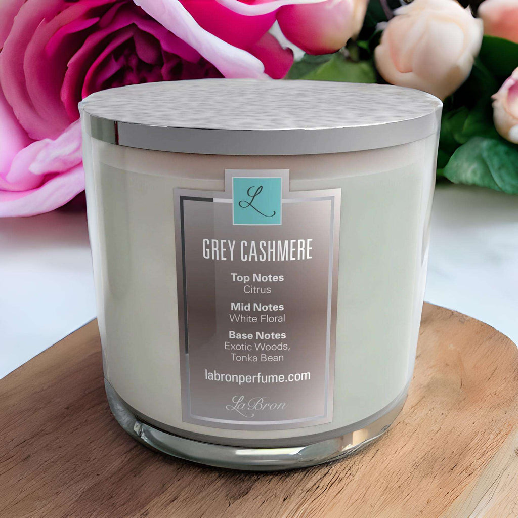Grey Cashmere candle with a grey lid and a floral background. Highly scented with citrus as their top note, white floral with their mid note and finished off with an exotic woods, tonka bean base note.