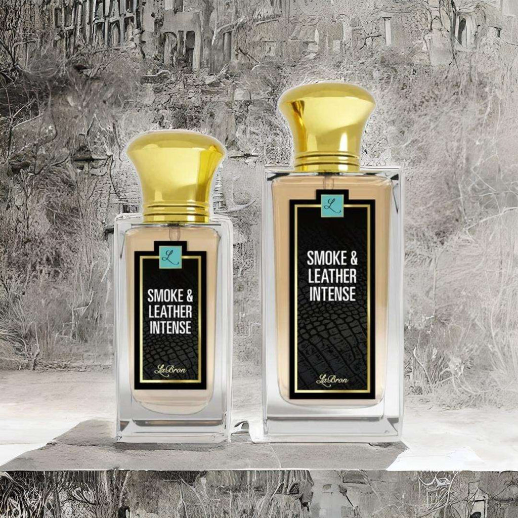 Two of the Smoke & Leather intense products sitting side by side and set on a marble like structure that reflects the same background. 