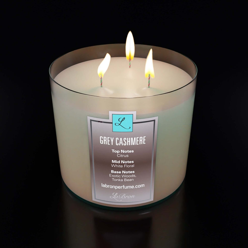Grey Cashmere candle with their logo, base, mid, and base notes emphasis on their label with a black background. 