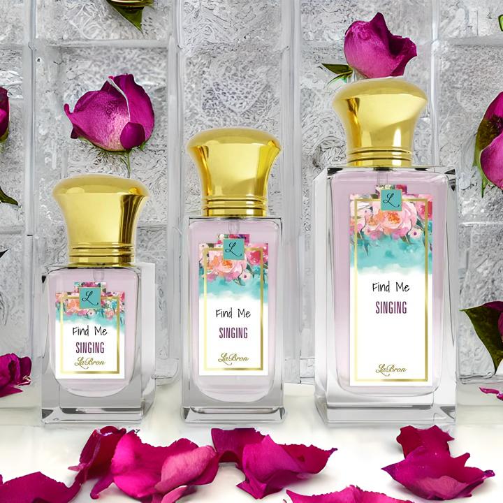 Find me "Singing" products showcased in a line. This products shows a floral like background on their label and gold cap. The background of the image is surrounded by purple like rose petals with a marble block background.