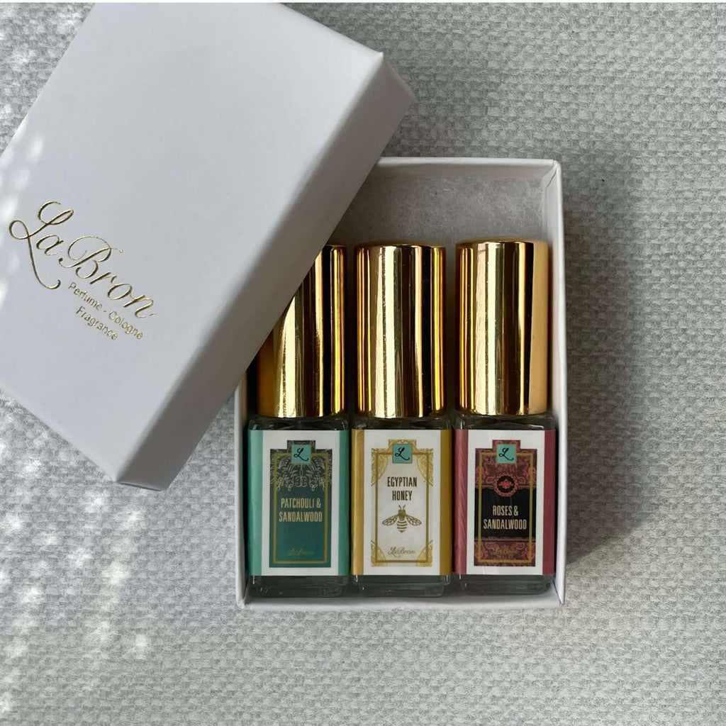 LaBron Perfume Sample Set; with your choice of Three or Six 5 ml Sprays. The box that comes with the products are in a white box with gold lettering for the label. The background is a mesh white look that brings it all together.