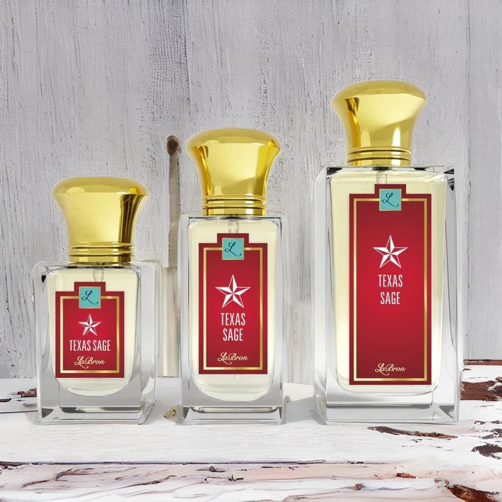 Three Texas Sage products from smallest to biggest with a red label and white lettering. The background shows a rustic wooden white look to it. 